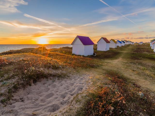 Cabines de gouville au soleil couchant à Gouville-sur-Mer