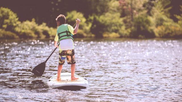 Enfant sur un stand up paddle en rivière